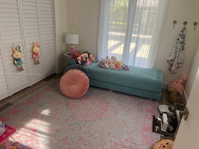 bedroom with dark wood-type flooring, a closet, and multiple windows