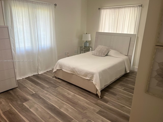 bedroom with dark hardwood / wood-style floors