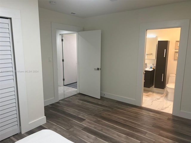 unfurnished bedroom with dark tile floors and ensuite bathroom