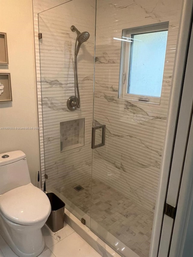 bathroom with an enclosed shower, tile floors, and toilet