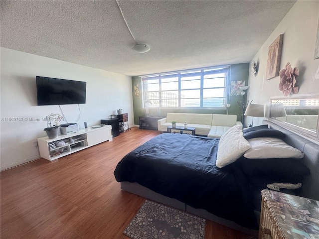 bedroom with hardwood / wood-style floors and a textured ceiling