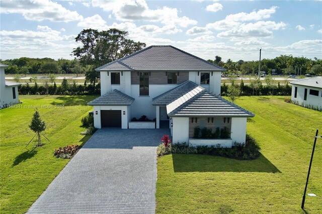 view of front of property with a garage and a front lawn