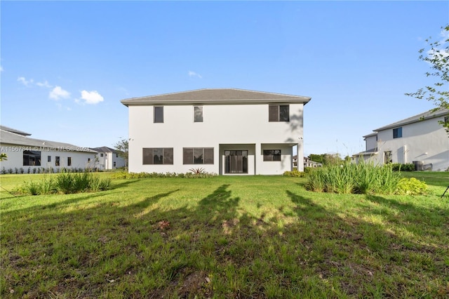 rear view of house featuring a yard