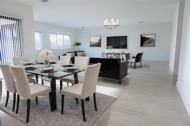 tiled dining area with an inviting chandelier