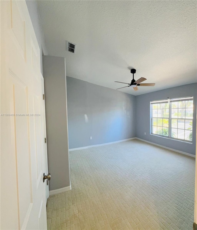 unfurnished room with a textured ceiling and ceiling fan