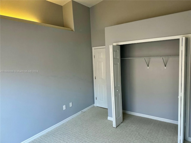 unfurnished bedroom with a closet and light tile floors