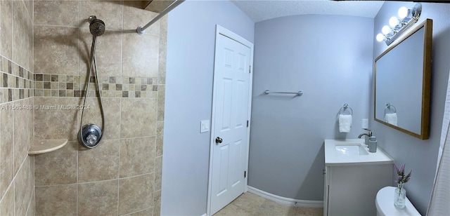 bathroom with vanity, toilet, tile floors, and a textured ceiling