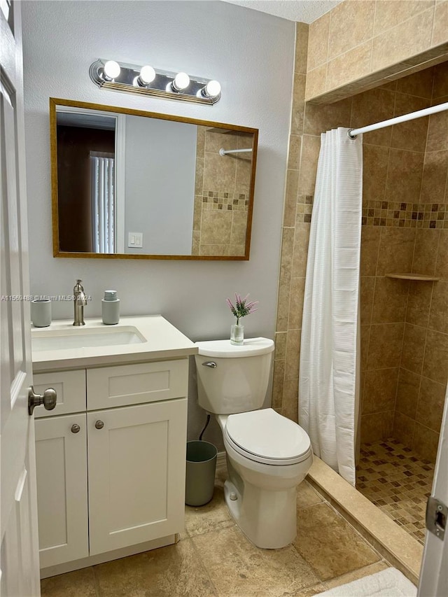 bathroom with a shower with shower curtain, vanity, toilet, and tile flooring