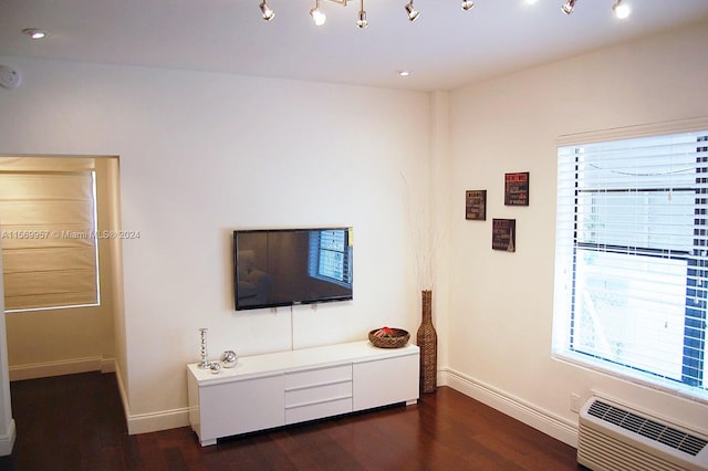 unfurnished living room with rail lighting and dark hardwood / wood-style floors