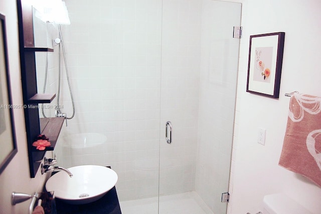 bathroom with sink, toilet, and a shower with shower door