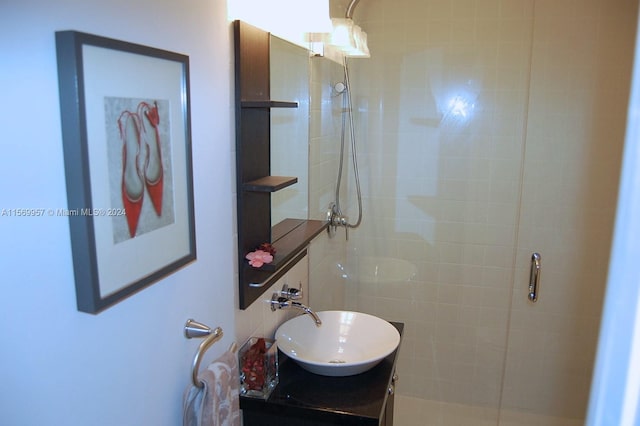 bathroom featuring a shower with door and vanity