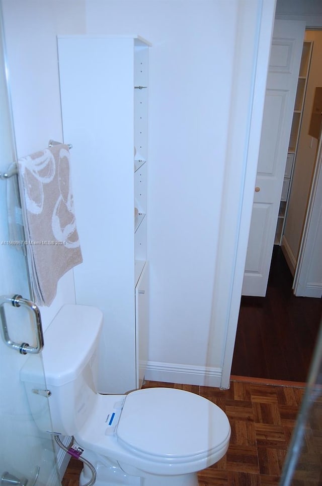 bathroom with parquet flooring and toilet