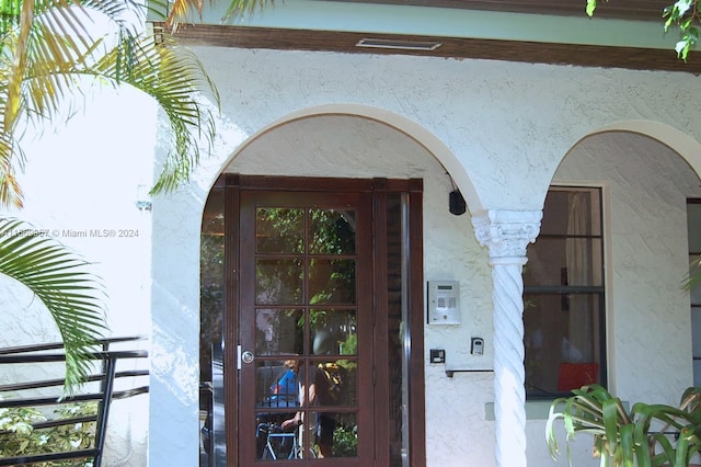 view of exterior entry with a balcony