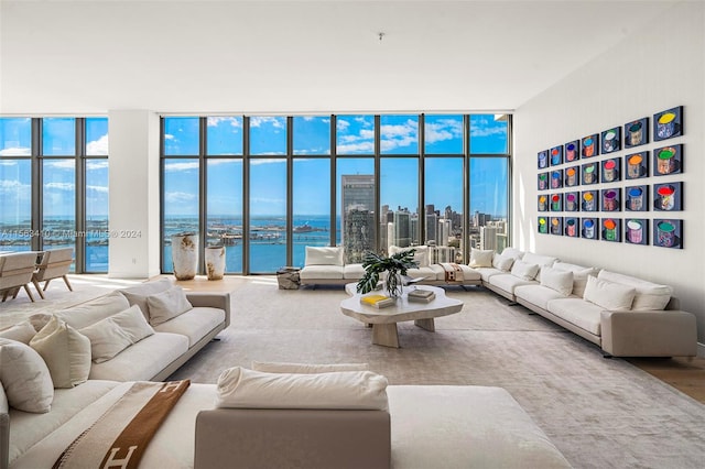 living room with a water view, plenty of natural light, and expansive windows