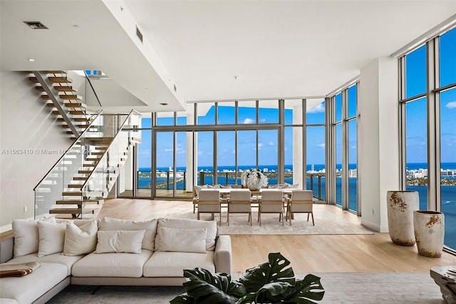 living room with a water view, plenty of natural light, and light hardwood / wood-style floors