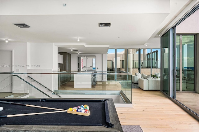 interior space featuring floor to ceiling windows, light hardwood / wood-style flooring, and billiards