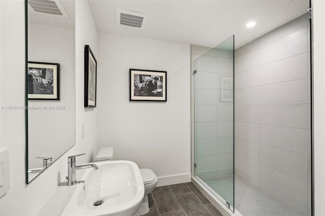 bathroom with sink, an enclosed shower, tile floors, and toilet