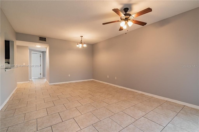 unfurnished room with ceiling fan with notable chandelier and light tile floors