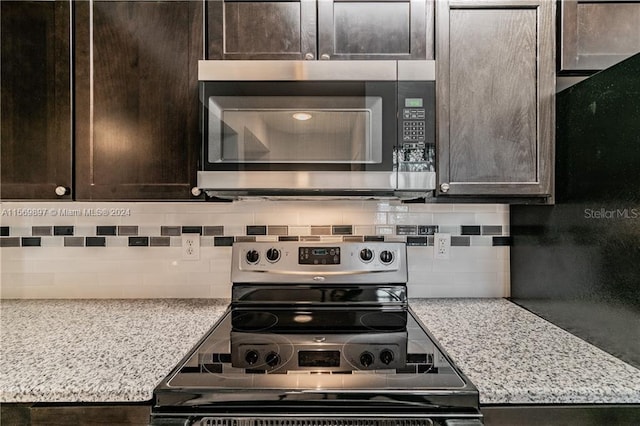 kitchen featuring appliances with stainless steel finishes, dark brown cabinetry, tasteful backsplash, and light stone counters