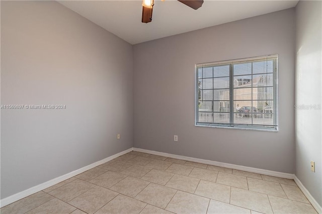 spare room with ceiling fan and light tile flooring