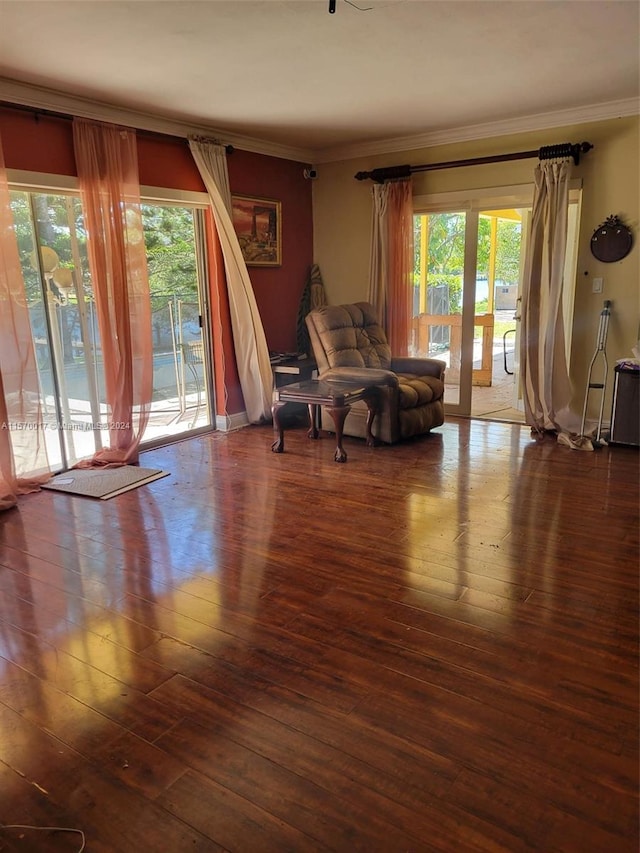 living room featuring hardwood / wood-style flooring, a healthy amount of sunlight, and crown molding