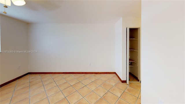 spare room featuring ceiling fan and light tile floors