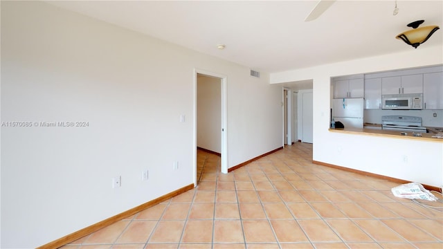 unfurnished living room featuring light tile floors