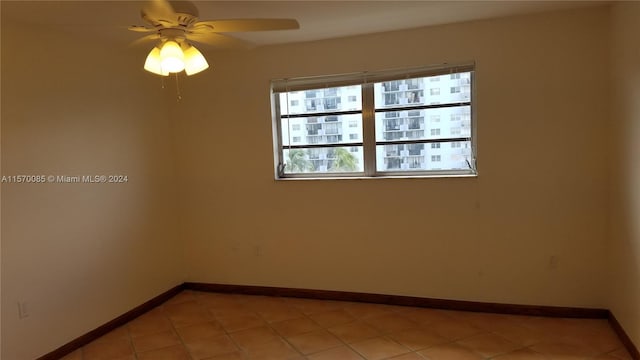 tiled spare room with ceiling fan