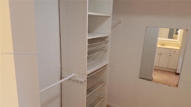 spacious closet featuring sink and light tile flooring