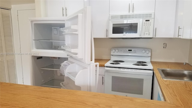 kitchen featuring white cabinets, sink, and white appliances