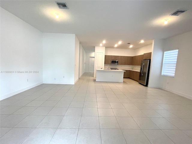 unfurnished living room featuring light tile flooring