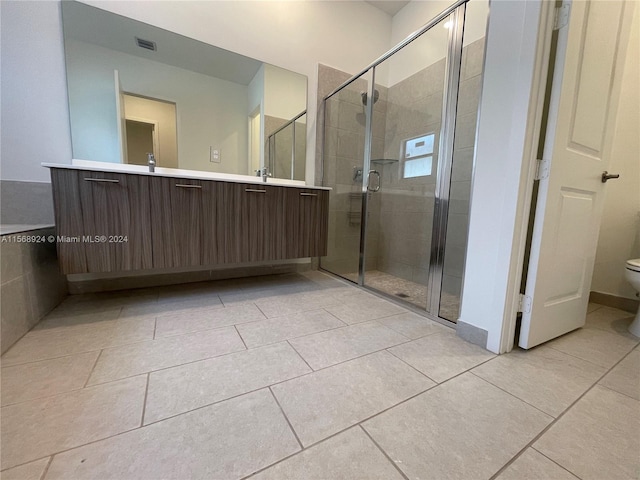 bathroom with a shower with shower door, toilet, tile floors, and vanity