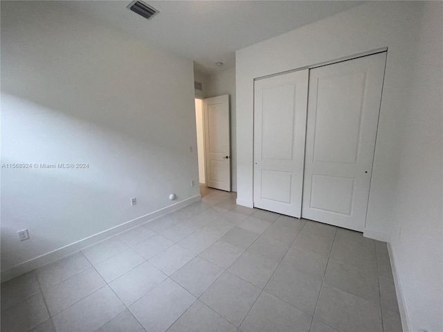 unfurnished bedroom featuring a closet and light tile flooring