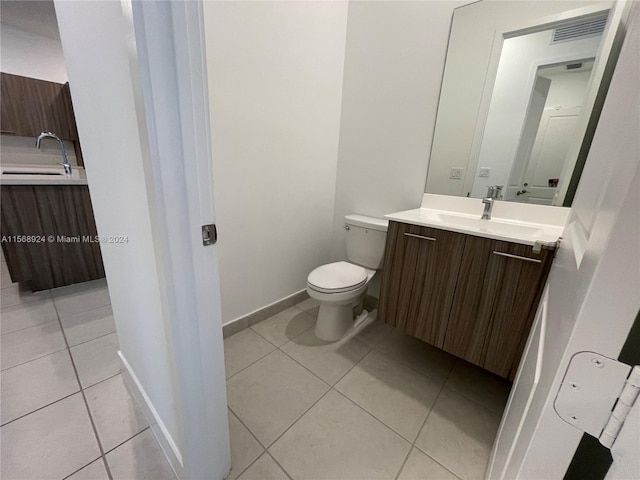 bathroom with vanity, toilet, and tile flooring