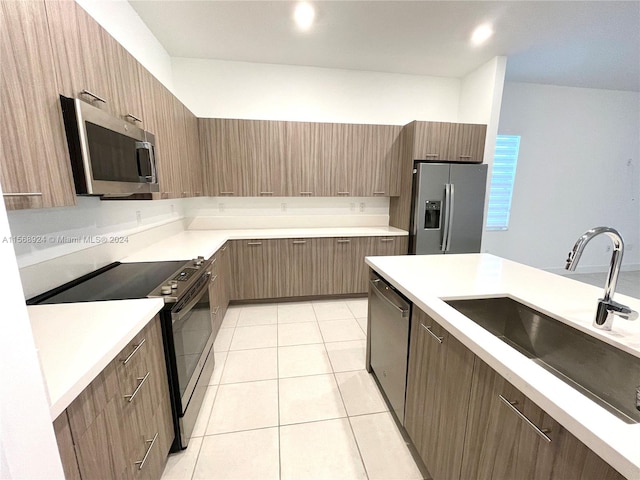 kitchen featuring sink, appliances with stainless steel finishes, and light tile floors