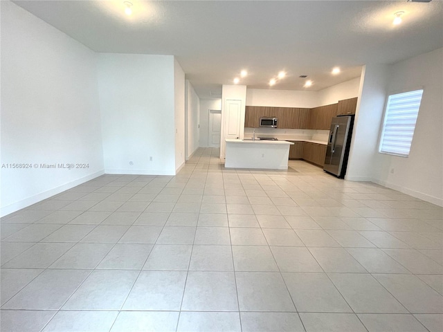 unfurnished living room with sink and light tile flooring