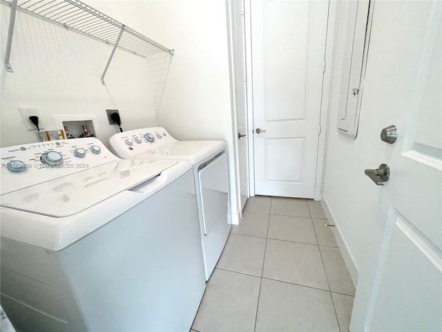 laundry room with hookup for an electric dryer, light tile flooring, washer hookup, and separate washer and dryer