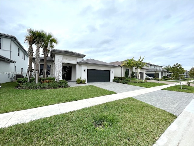 view of front of home with a garage, a front lawn, and central air condition unit