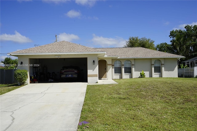 ranch-style house featuring a front lawn and a garage