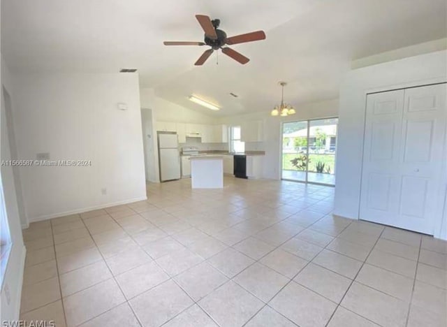 unfurnished living room with ceiling fan with notable chandelier, vaulted ceiling, and light tile floors