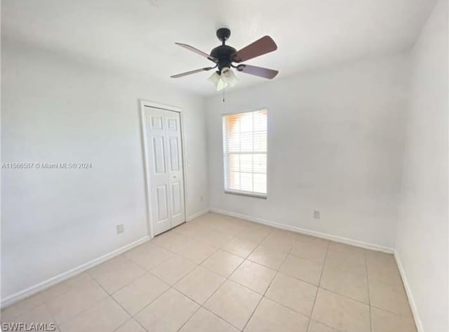 spare room featuring ceiling fan and light tile flooring