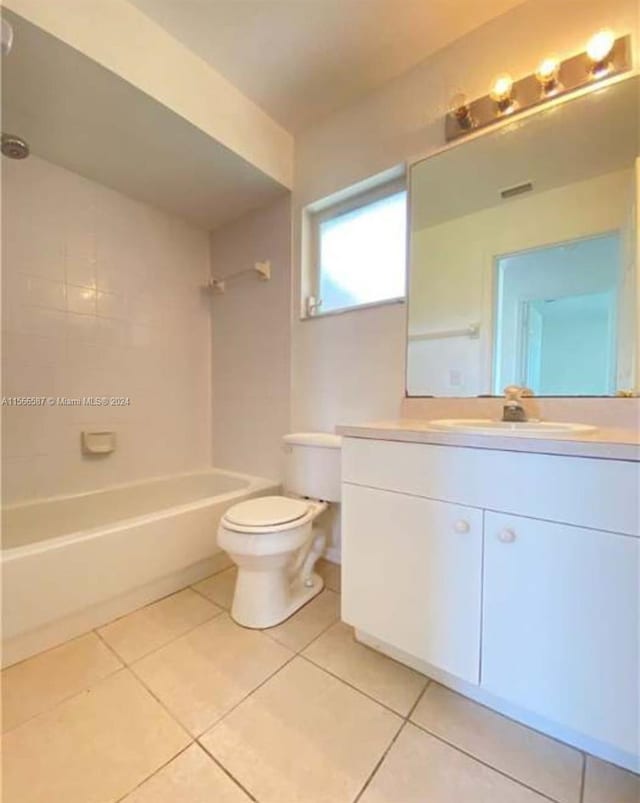 full bathroom with tile flooring, tiled shower / bath, toilet, and vanity with extensive cabinet space