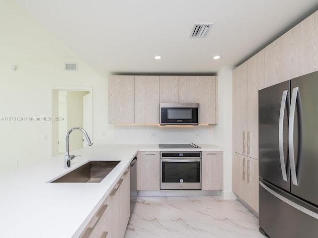 kitchen featuring light brown cabinetry, sink, appliances with stainless steel finishes, and light tile flooring