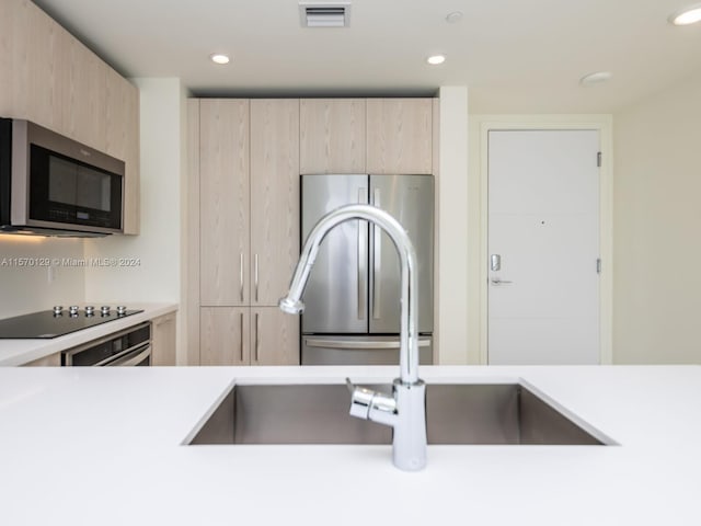 kitchen with appliances with stainless steel finishes and light brown cabinetry