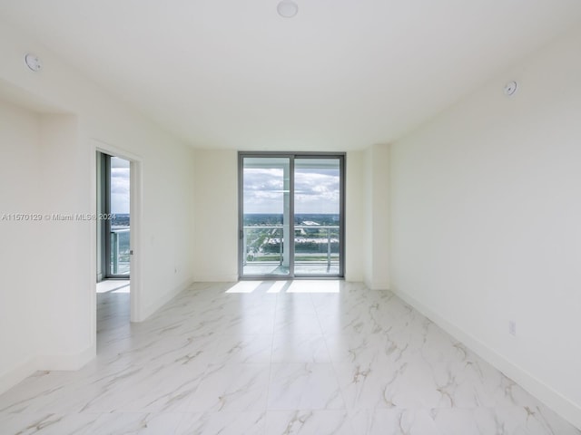 tiled spare room featuring floor to ceiling windows and plenty of natural light