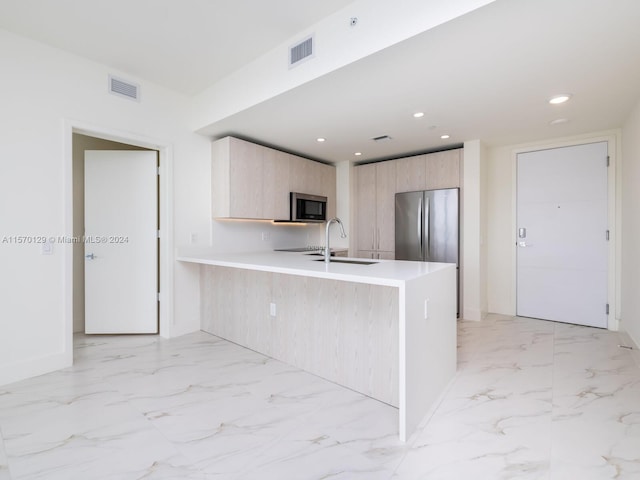 kitchen featuring light brown cabinetry, sink, appliances with stainless steel finishes, and light tile floors