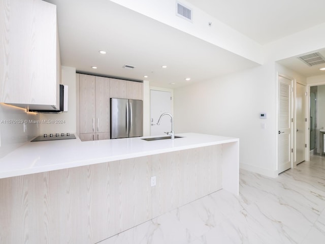 kitchen featuring black electric cooktop, light tile flooring, stainless steel refrigerator, light brown cabinetry, and sink