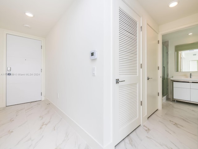 corridor featuring sink and light tile floors