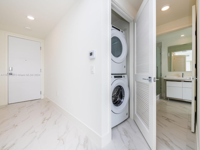 clothes washing area with stacked washer / drying machine, sink, and light tile floors