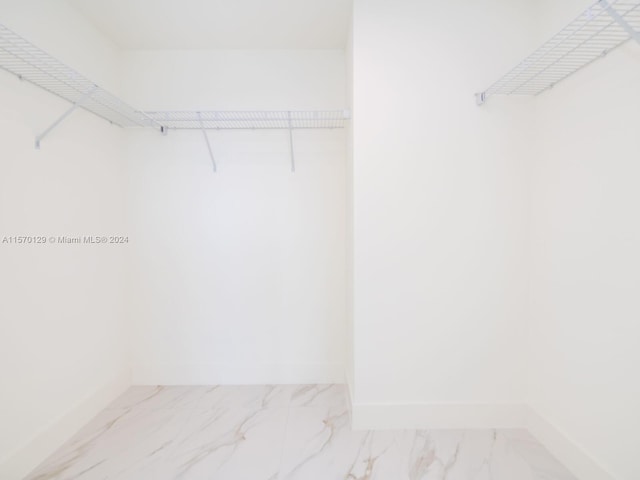 walk in closet with light tile floors